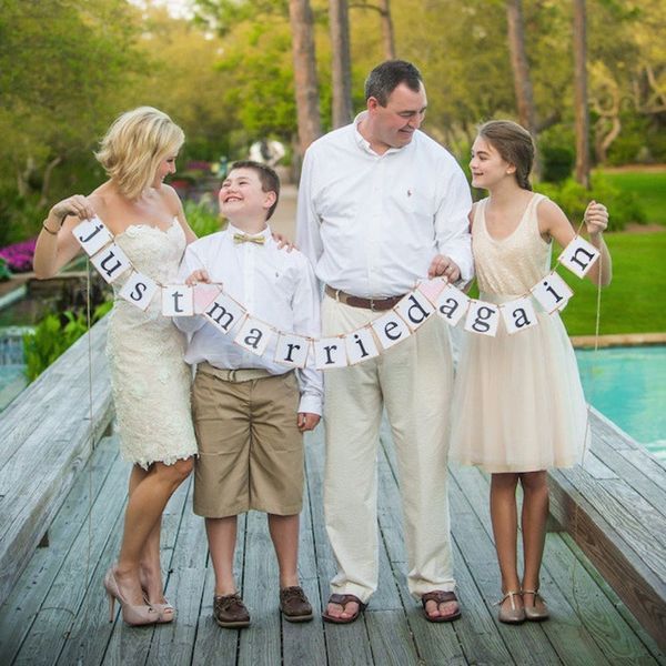 family celebrating a vow renewal ceremony on a bridge with letters hanging between them