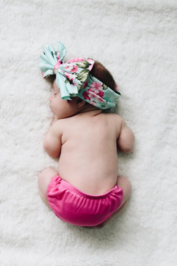 kelly-sikkema-If7eM-f7Ehg-unsplash-2-683x1024 baby in pink nappy and headband lying on a rug Family and Naming Ceremonies in Aberdeen