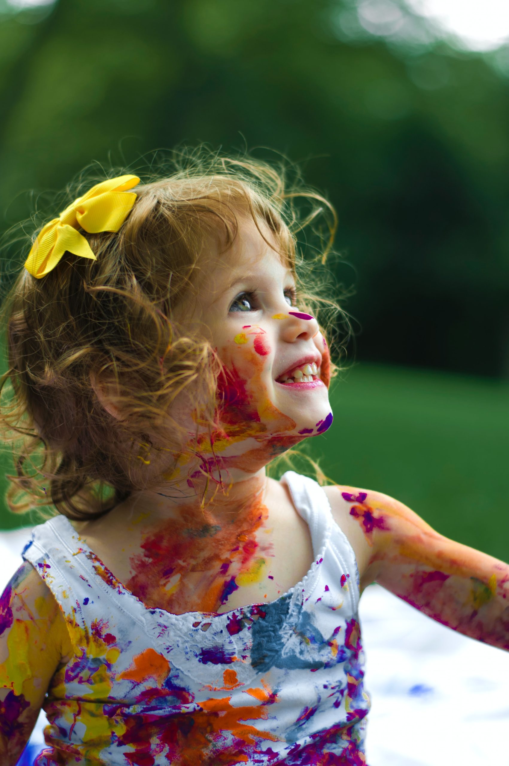 senjuti-kundu-JfolIjRnveY-unsplash making a naming ceremony fun little girl with her face all painted and a yellow bow in her hair