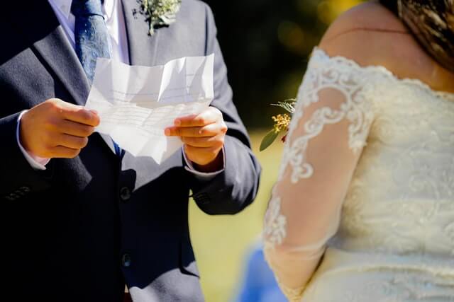 tai-s-captures-OJoiCaJfXDQ-unsplash-1 couple at a wedding reading their vows to each other vow renewal ceremony with the celebrant angel