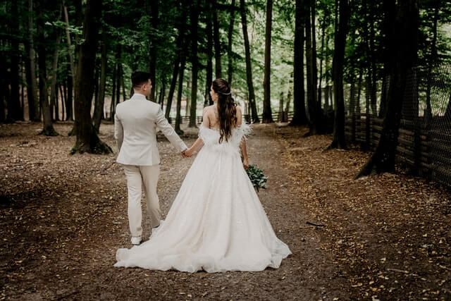 victoria-priessnitz-jsEtADZdo4M-unsplash-1 couple walking down the aisle in a forest setting