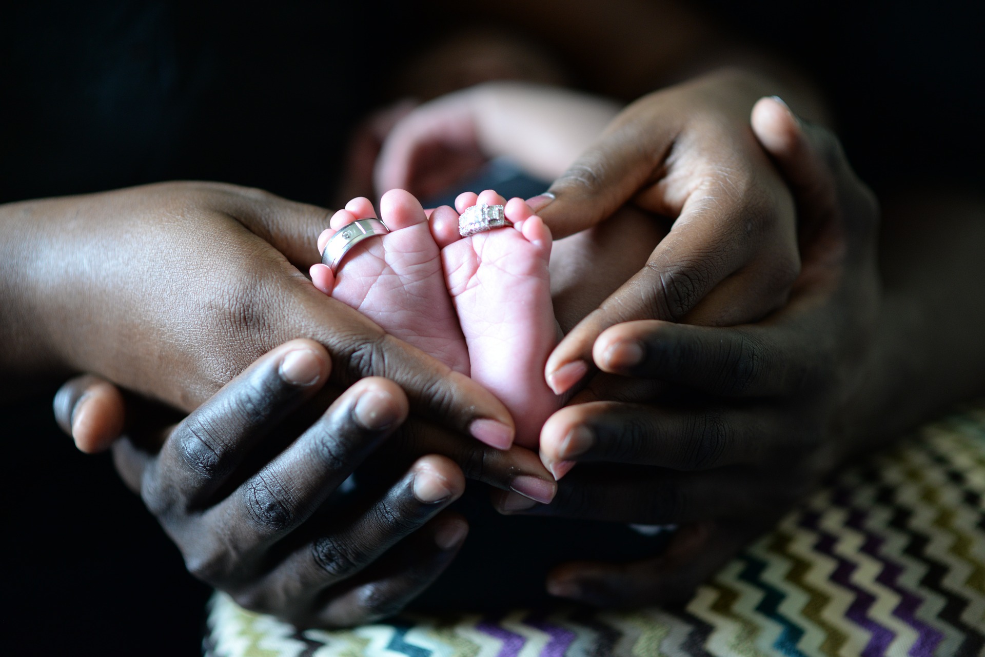 baby-1150109_1920 parents hands holding tiny baby feet in their hands family and naming ceremonies in aberdeen