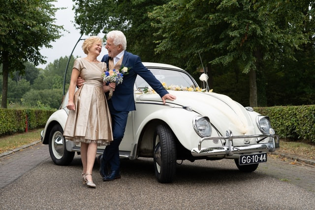 med_res photo of couple standing beside a car during a commitment ceremony