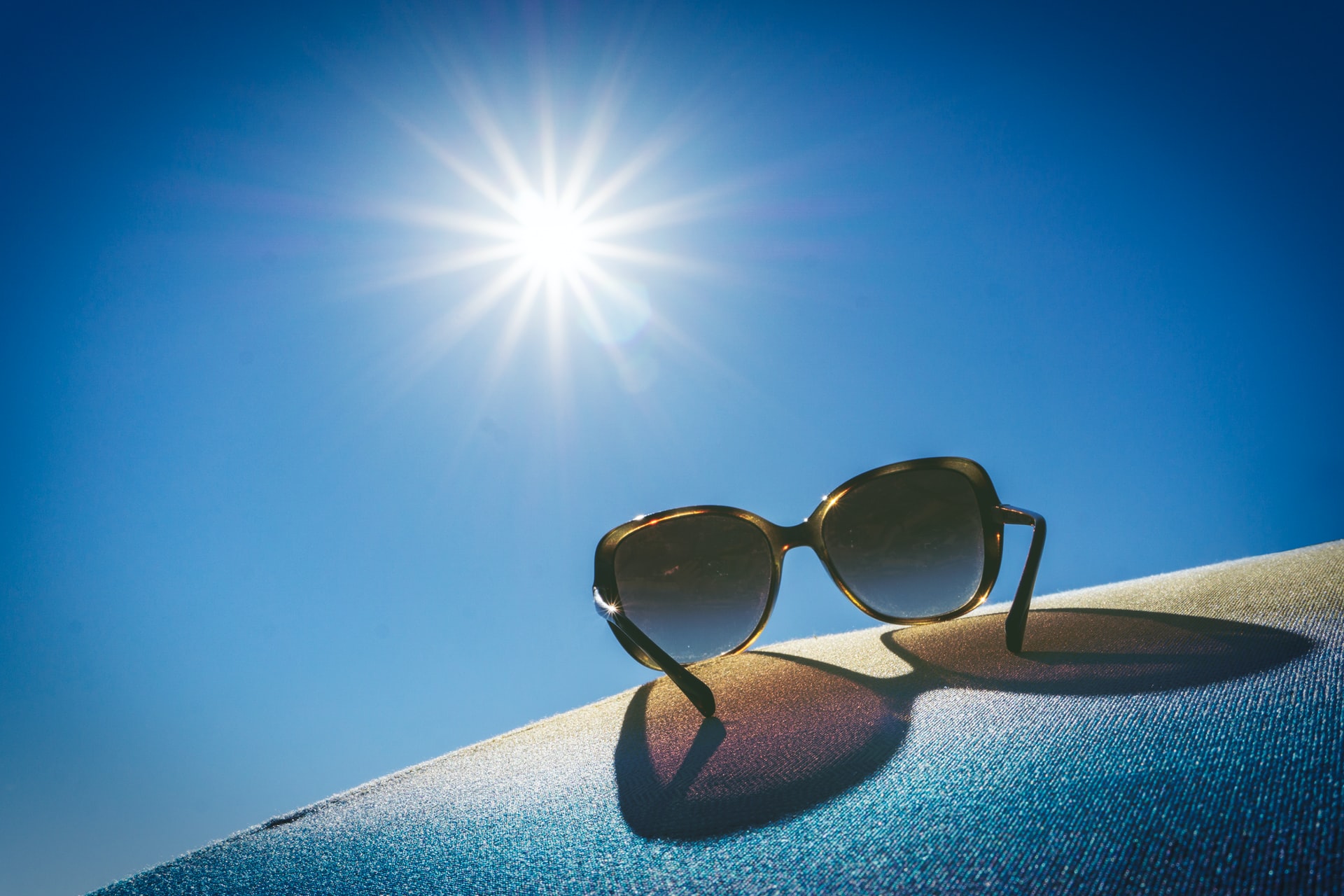 herbert-goetsch-VMszlfU17ds-unsplash how to keep your guests cool in summer, picture of the sun and sun glasses with the celebrant angel
