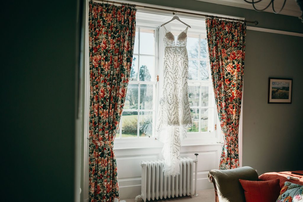 a photo of a wedding dress hanging in a window from the blog wedding dress shopping what do you need with mary gibson the celebrant angel aberdeen