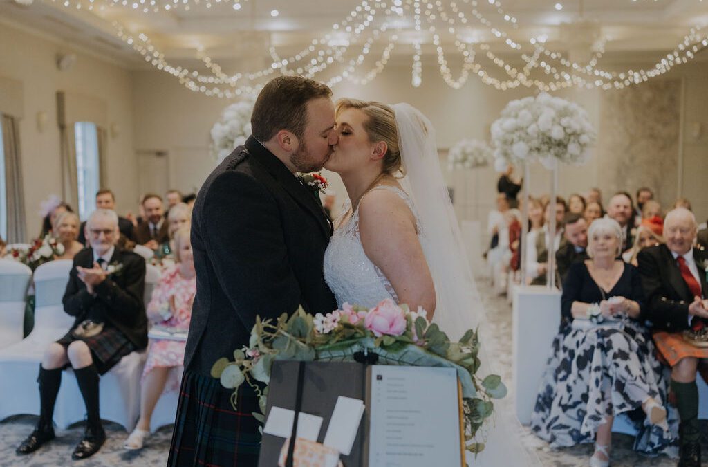 photo of scott and frances onder kissing during the wedding ceremony with mary gibson the celebrant angel at maryculter house hotel aberdeen