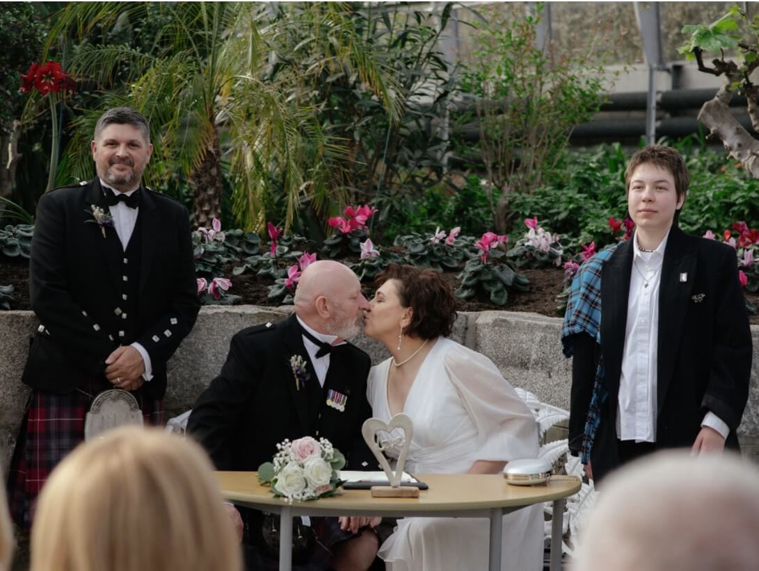 David and Olena's wedding at the winter gardens Aberdeen, the couple kissing 