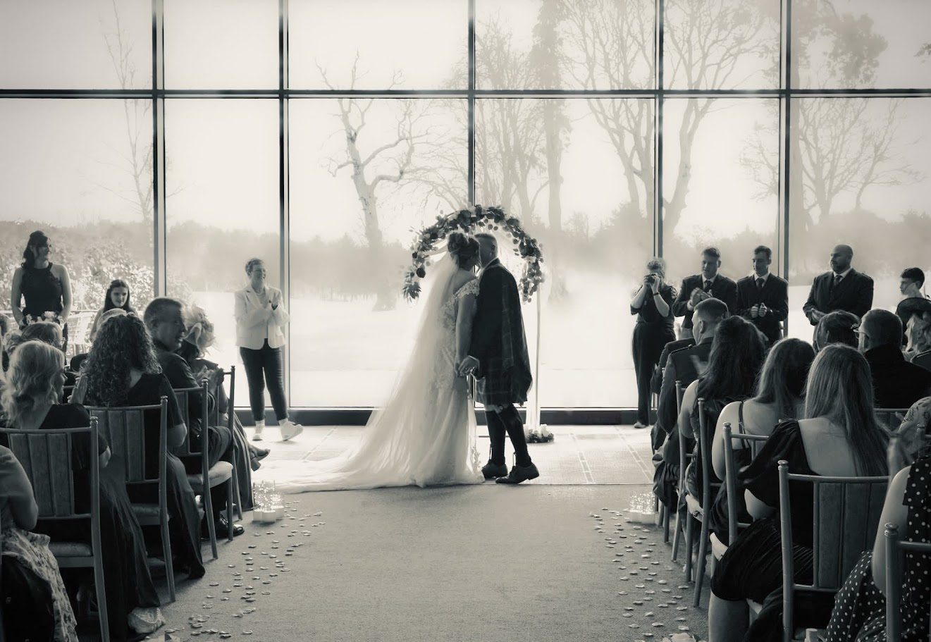 a couple doing their first kiss as husband and wife in their wedding ceremony at Meldrum House
