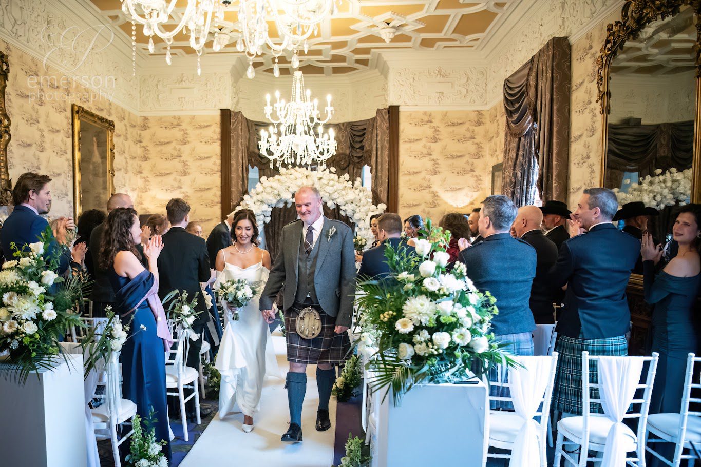 A couple walking back up the aisle at Ardoe House after their ceremony 