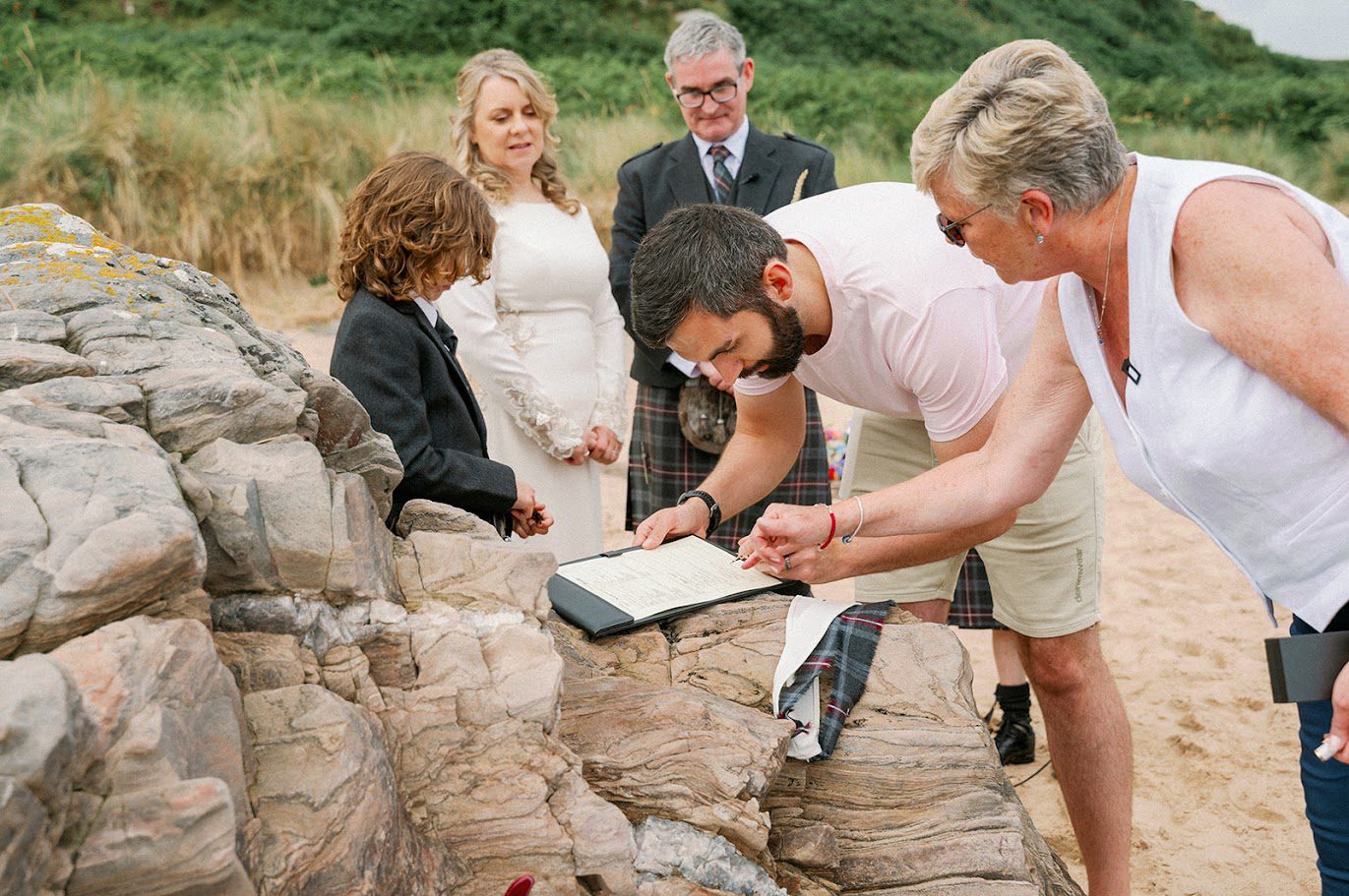  a wedding ceremony for two, with the witnesses signing the paperwork