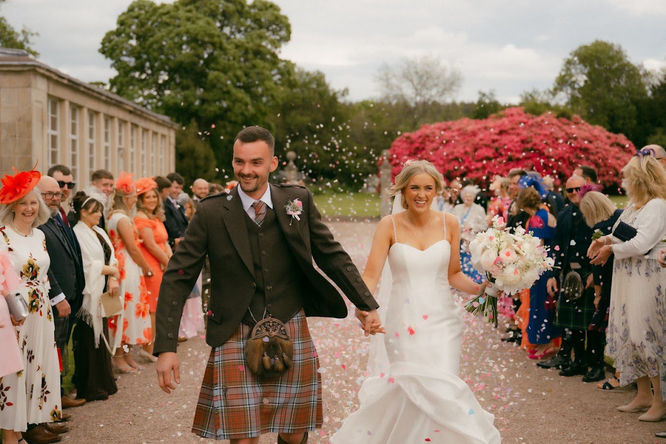 Chris and Sophie walking through the confetti at Gordon Castle